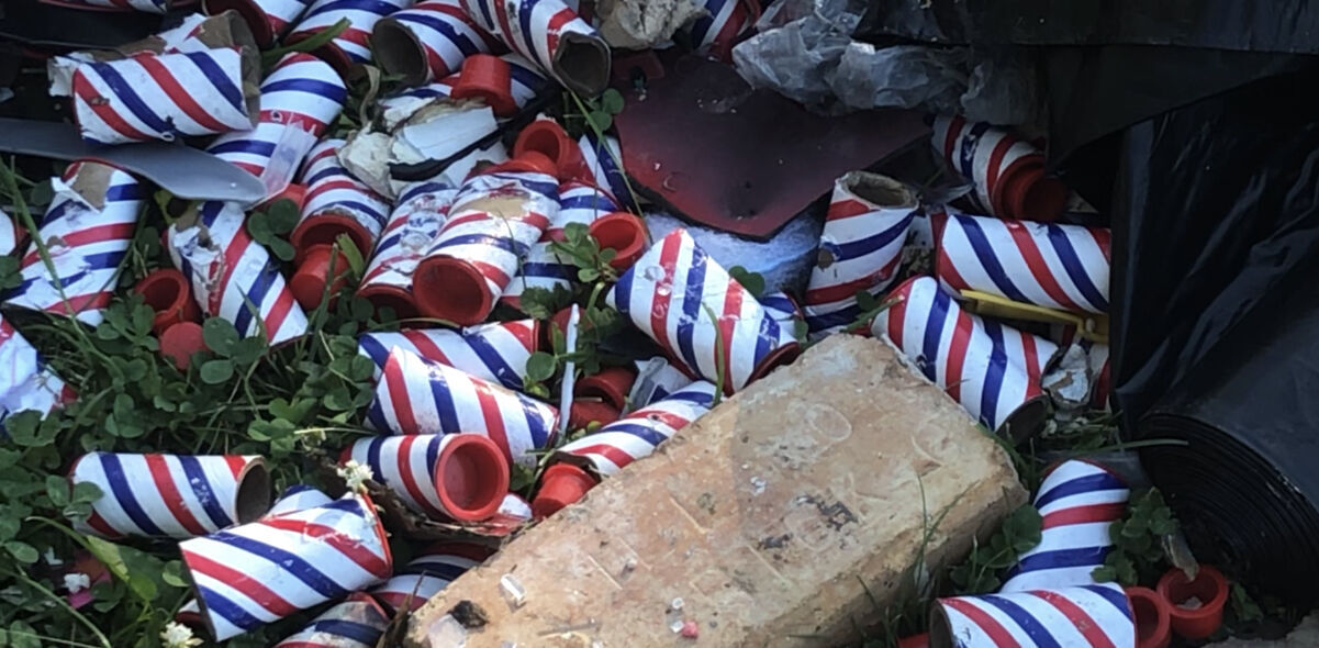 Cardboard canisters for fireworks litter yard after house explosion